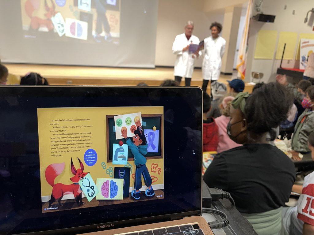 Figure 7: Closeup of a projection of the oncology book that was being read to the students during the book assembly at ACSC. Photo by Dieuwertje Kast